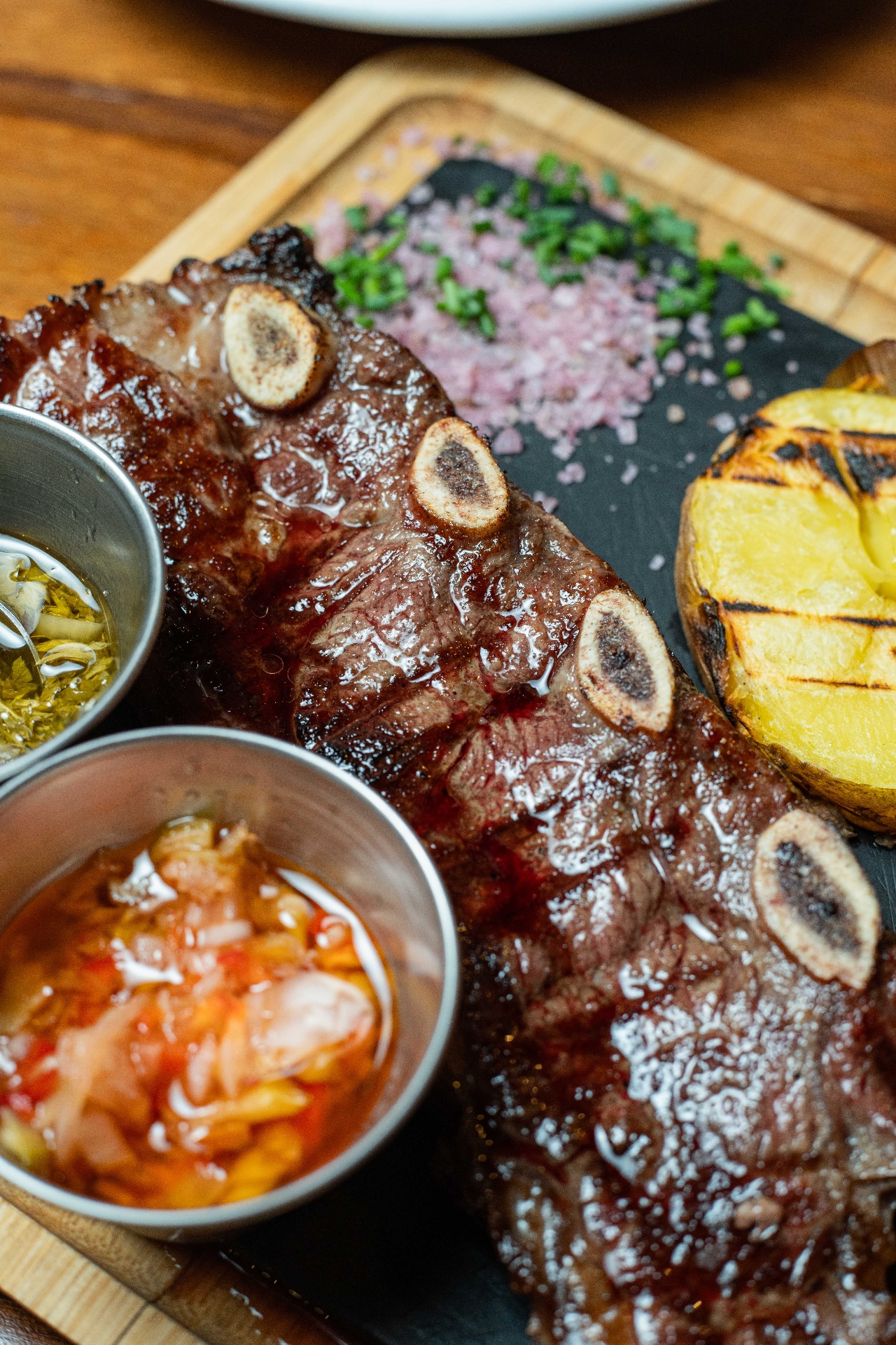 Tira de asado argentino con chimichurri y salsa criolla